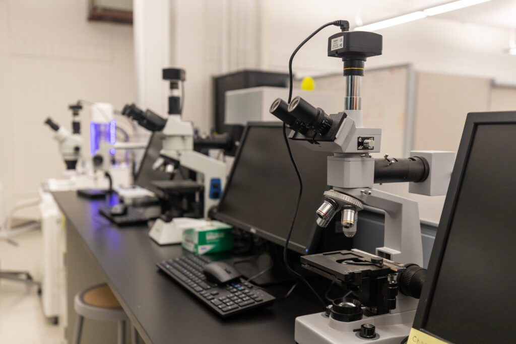 Computers and telescopes on a table in the AMIC lab