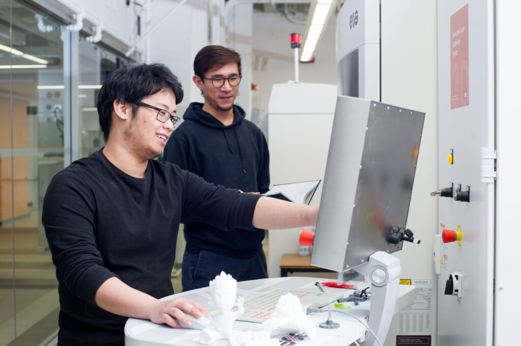 Two students working in the Additive Manufacturing Innovation Centre lab in Mohawk College.