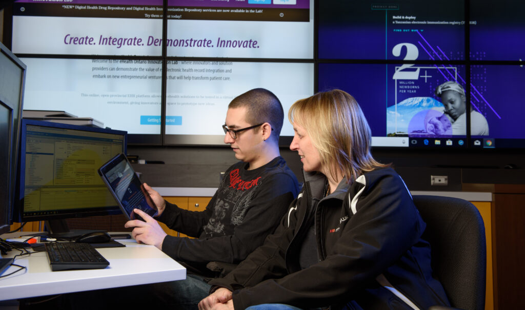 Faculty and student collaborating in the MEDIC office at Mohawk College